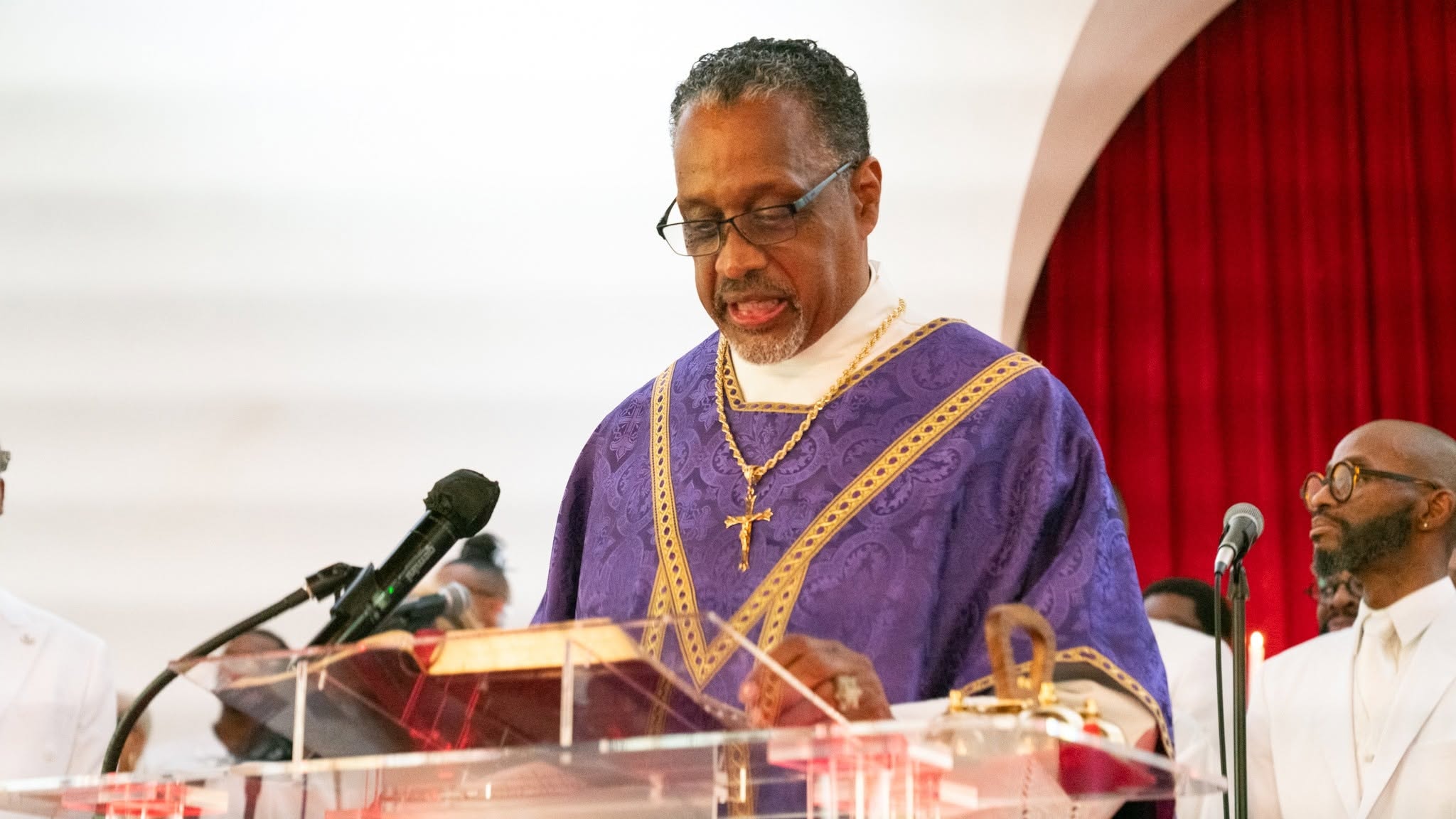 Reading from the Word — robed in purple and gold
