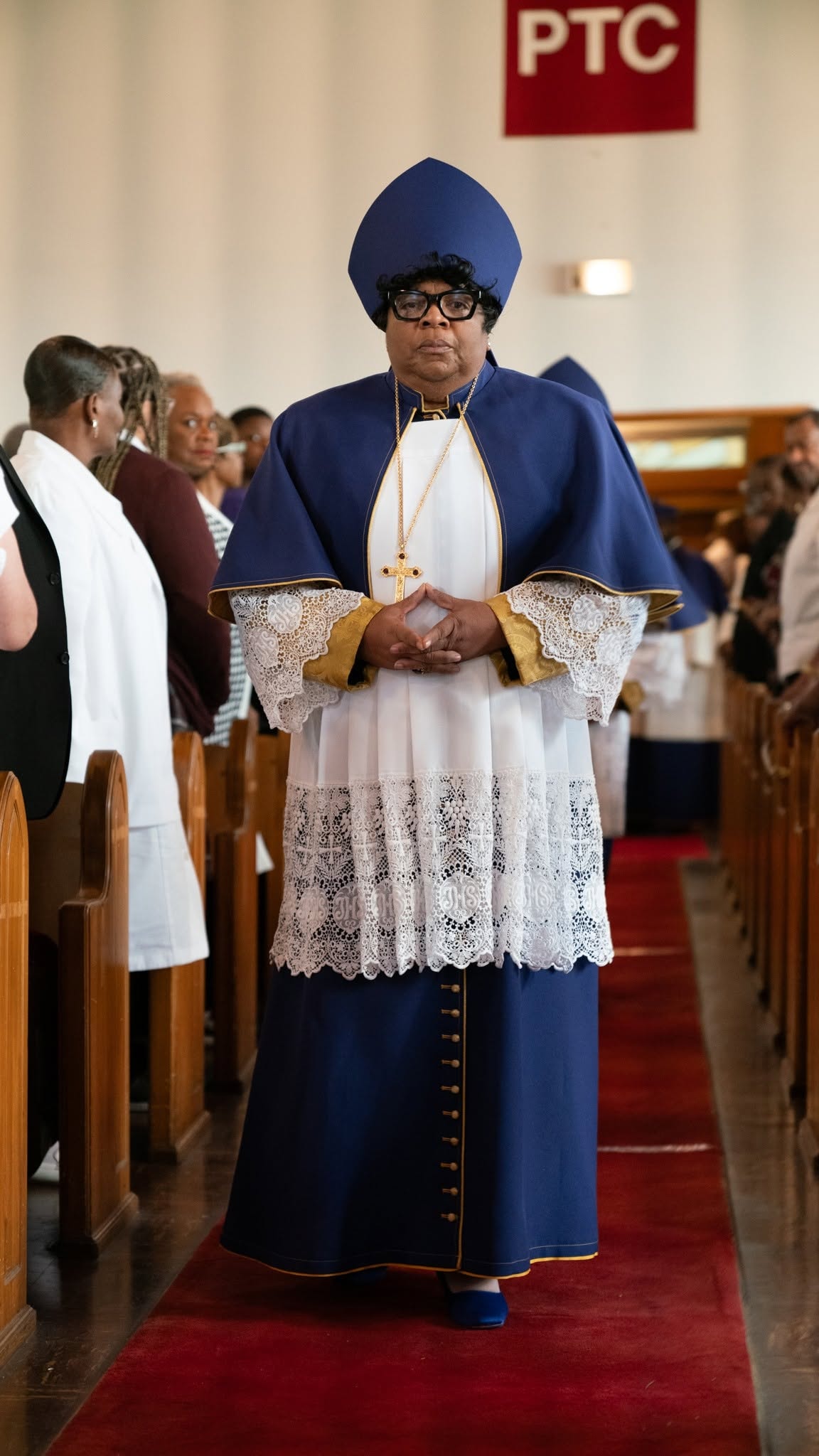 Robed in blue and gold — a woman of God walks the aisle